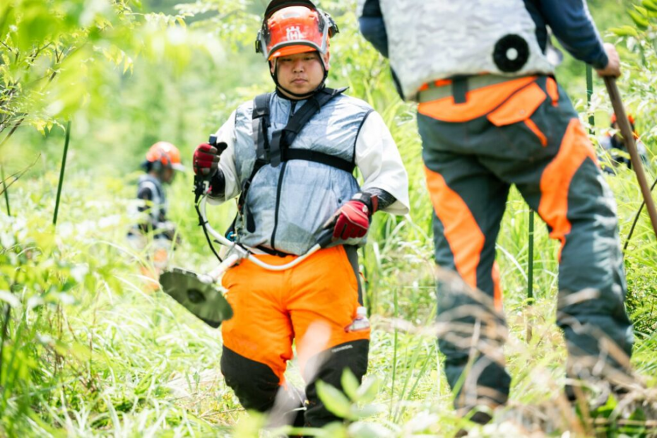 真剣に草刈りの実習に臨む学生の様子