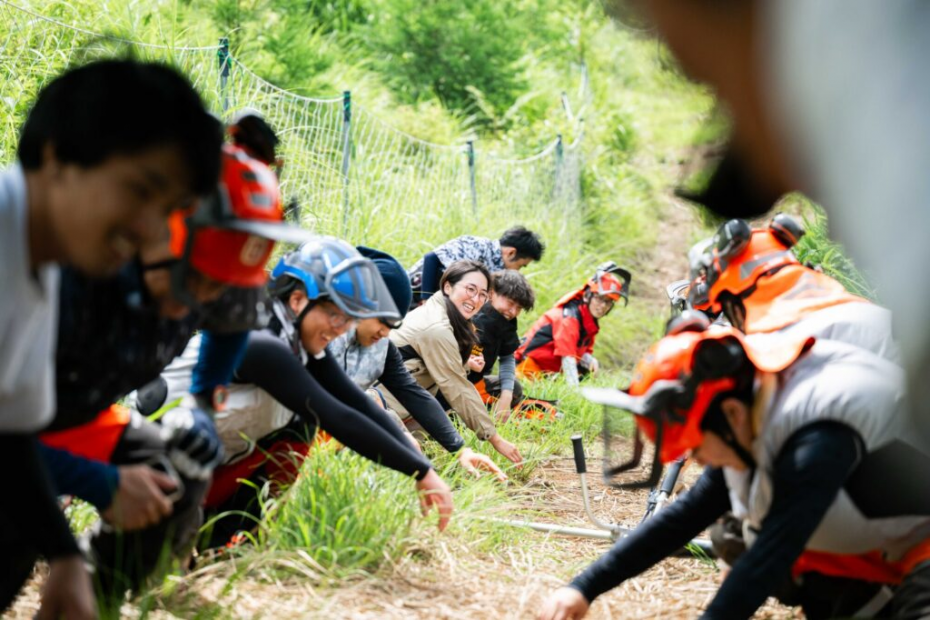 草刈りの実習の前にみんなで準備体操をする様子